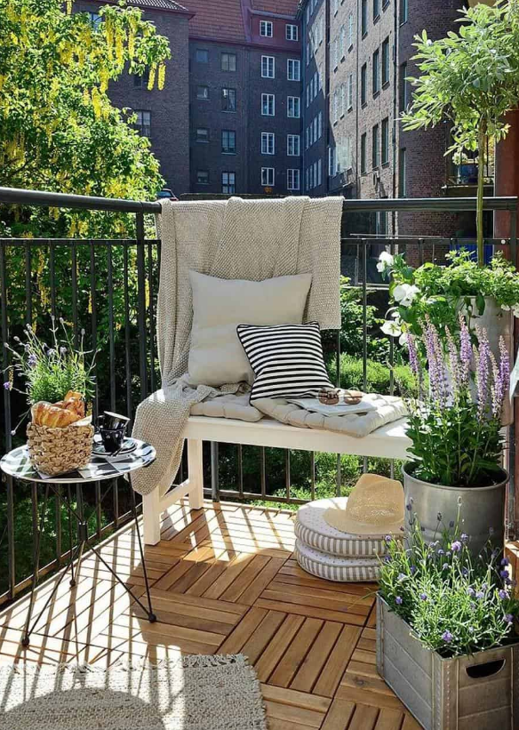 Balcon avec tapis d’extérieur et jardinières regroupées dans les coins